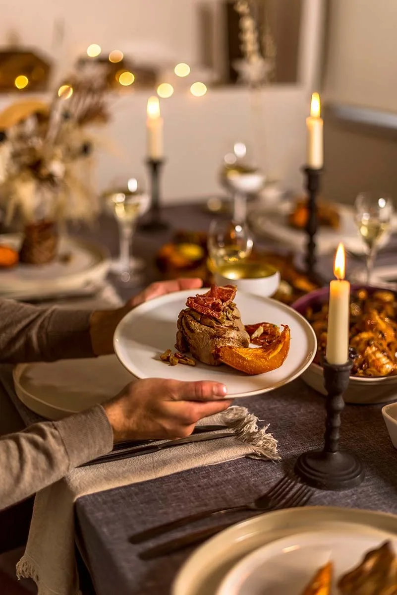 Plato de carne en una mesa de Navidad con velas en Taberna del Cura